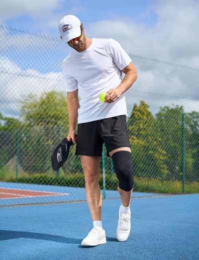 A man wearing the Airflow React Knee Support playing Pickleball with USA Pickleball merchandise - about to serve