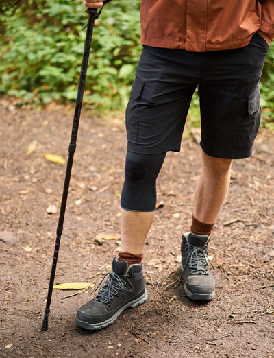 A man wearing an Airlfow React Knee Support whilst out hiking in some woods