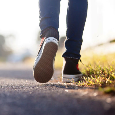 Person walking on path next to grass