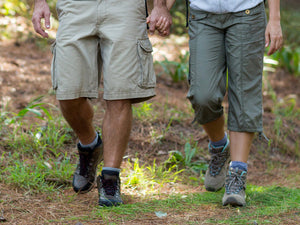 Two people wearing boots, walking in the woods