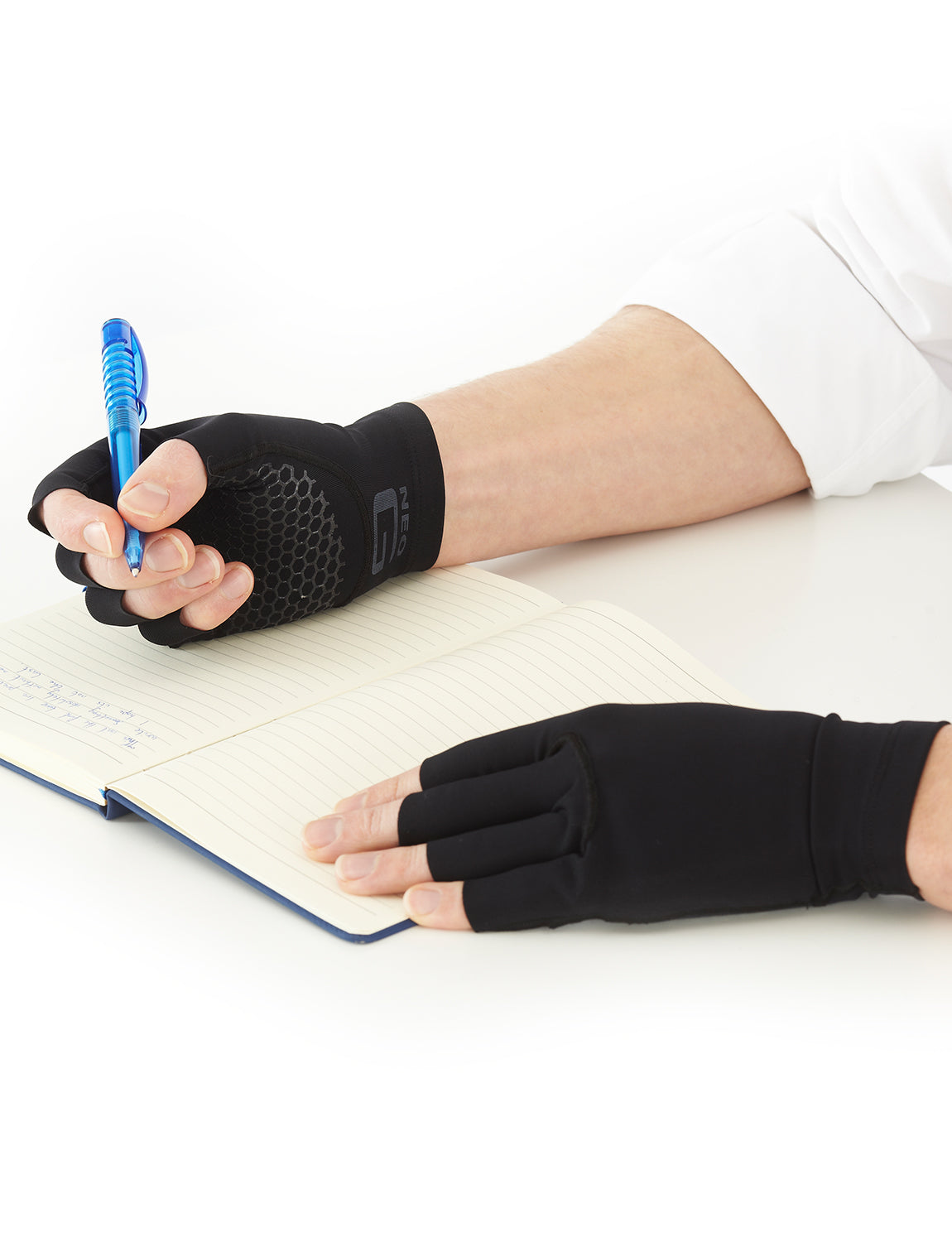 Pair of hands wearing Comfort/Relief Arthritis Gloves with only slimline Lifestyle gloves layer, writing