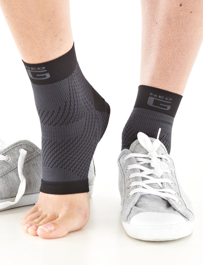 Pair of feet wearing Neo G Plantar Fasciitis Everyday Support, facing front, left foot has shoe overtop