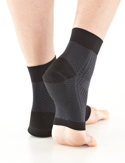 Pair of Feet wearing Neo G Plantar Fasciitis Everyday Support facing back with one foot elevated
