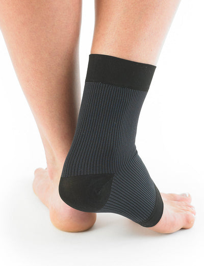 Pair of feet with one wearing black Neo G Airflow Ankle Support facing back