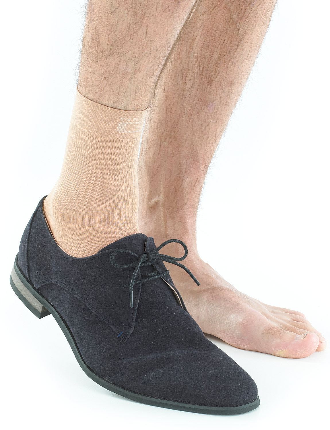 Pair of feet with one wearing beige Neo G Airflow Ankle Support and a suede shoe
