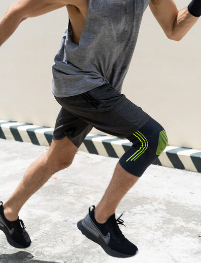 Woman wearing Neo G Active Knee Support on right leg running