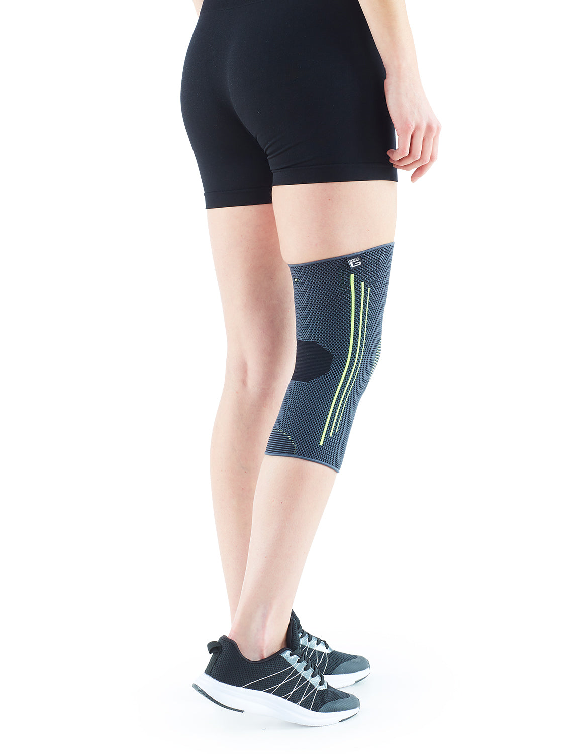 Woman wearing Neo G Active Knee Support on right leg facing back