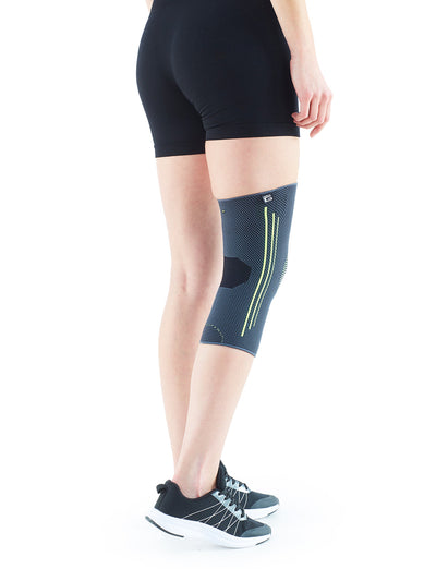 Woman wearing Neo G Active Knee Support on right leg facing back