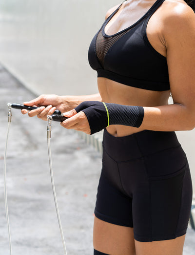Woman wearing Neo G Active Wrist Support holding jump rope