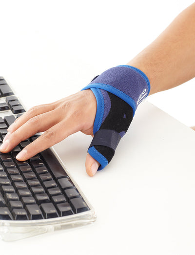 Hand wearing Neo G Easy-Fit Thumb Brace typing