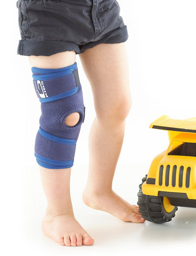 Child wearing Neo G Kids Open Knee Support next to toy car