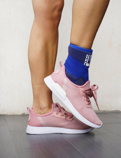 Woman wearing Neo G Ankle Support with Figure of 8 Strap under pink sneakers