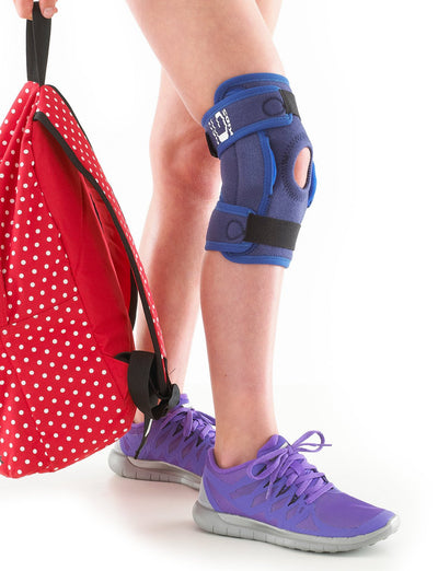 Child wearing Neo G Kids Hinged Knee Support, holding red backpack