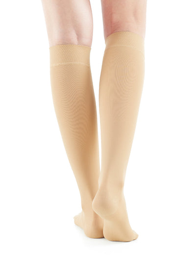 Woman wearing Beige Neo G Therapeutic Knee Highs (Closed Toe) facing back showing graduated compression