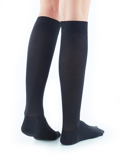 Woman wearing Neo G Energizing Dress Socks, facing back, showing shaped heel cup