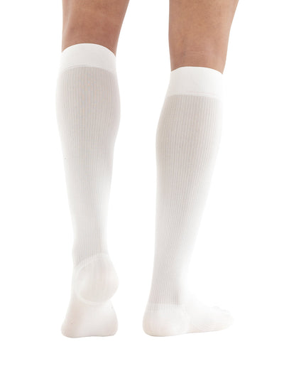 Woman wearing White Neo G Energizing Dress Socks facing back, showing shaped heel cup