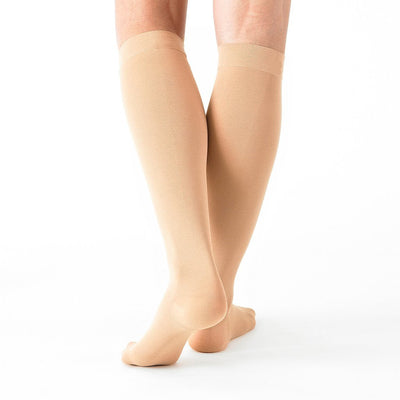 Woman wearing Beige Neo G Energizing Trouser Knee Highs, facing back, showing shaped heel cup