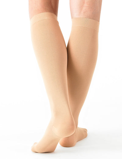 Woman wearing Beige Neo G Energizing Comfort Sheer Knee Highs, facing back, showing shaped heel cup