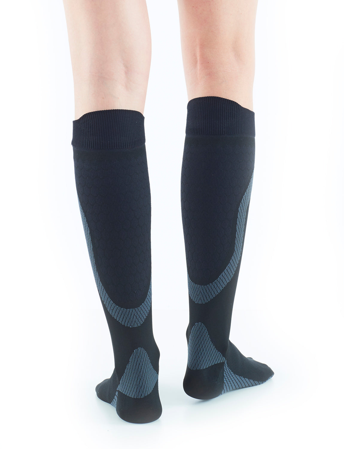 Woman wearing Black Neo G Energizing Active Socks facing back, showing shaped heel cup